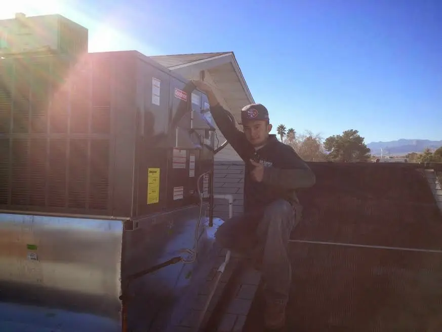 HVAC technician performing AC Tune-Up on a rooftop unit in Litchfield Beach