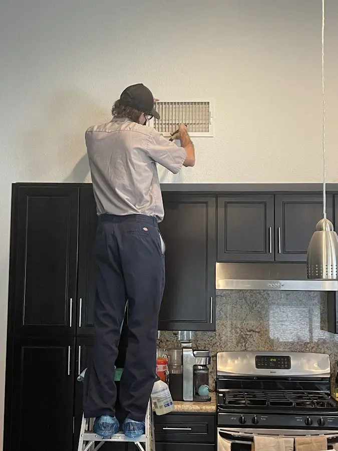 Technician inspecting an air vent during HVAC service in Litchfield Beach
